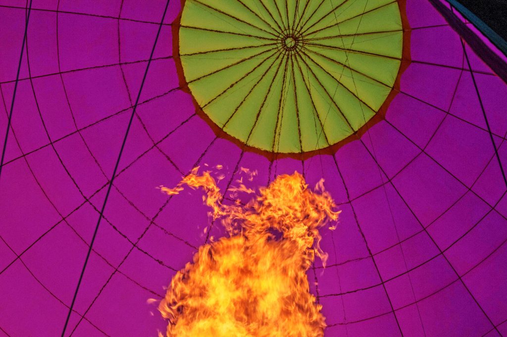 The flame illuminates the balloon while inflating 